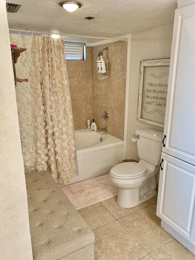 bathroom featuring a textured ceiling, tile patterned flooring, shower / bath combo, and toilet