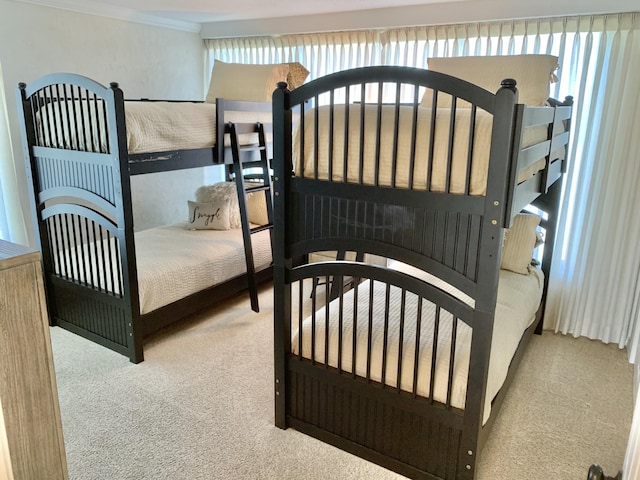 bedroom featuring light colored carpet and ornamental molding