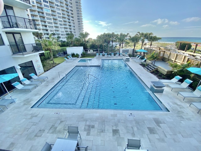 view of pool featuring a water view and a patio area