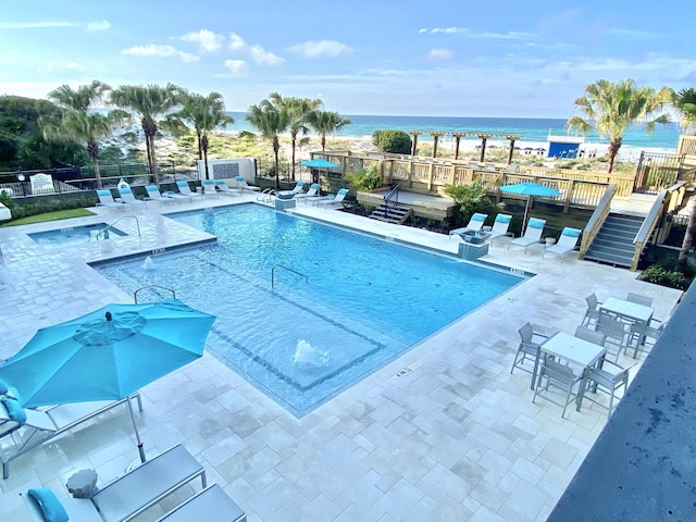 view of pool featuring a deck with water view and a patio area