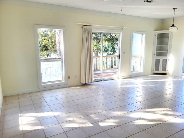 tiled spare room featuring a wealth of natural light