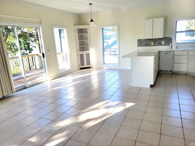 kitchen with kitchen peninsula, white cabinetry, white dishwasher, and a wealth of natural light