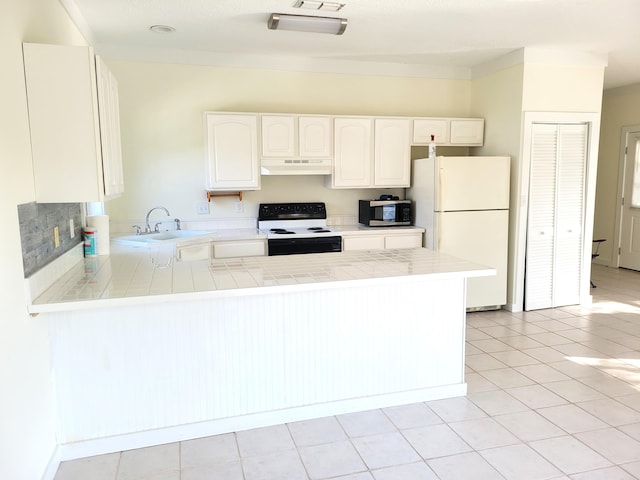 kitchen featuring tile countertops, white appliances, kitchen peninsula, light tile patterned floors, and white cabinetry