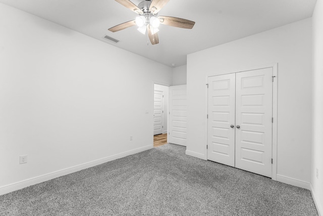 unfurnished bedroom with carpet, ceiling fan, and a closet