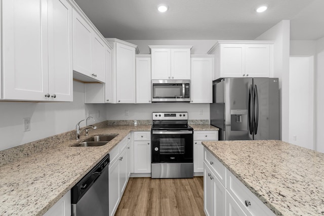 kitchen with white cabinetry, sink, light wood-type flooring, and stainless steel appliances