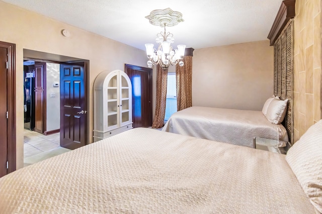 tiled bedroom with a textured ceiling and an inviting chandelier