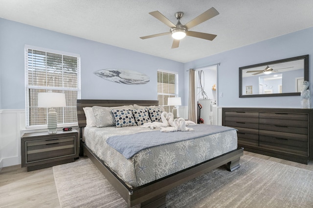 bedroom featuring a textured ceiling, light hardwood / wood-style floors, and ceiling fan