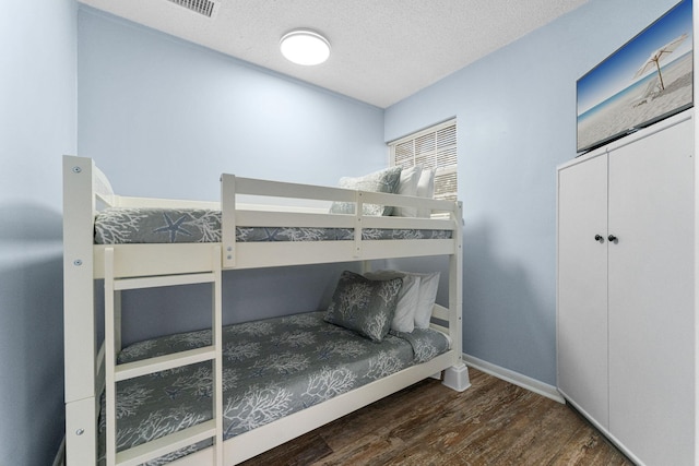 bedroom featuring a textured ceiling and dark wood-type flooring