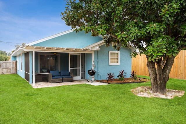 back of house featuring a sunroom and a yard