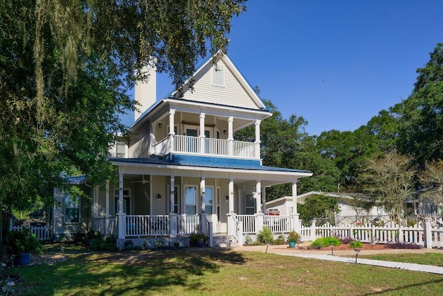 view of front of house featuring a front yard, a porch, and a balcony