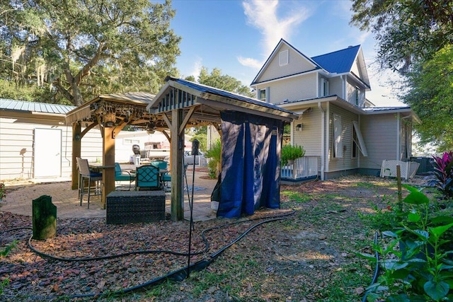 rear view of property featuring a gazebo and a patio area