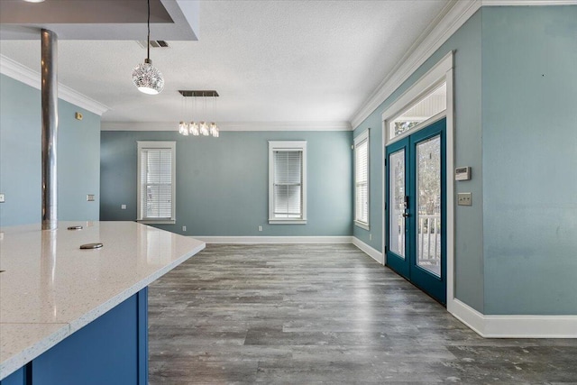 interior space featuring french doors, dark hardwood / wood-style flooring, a textured ceiling, and ornamental molding