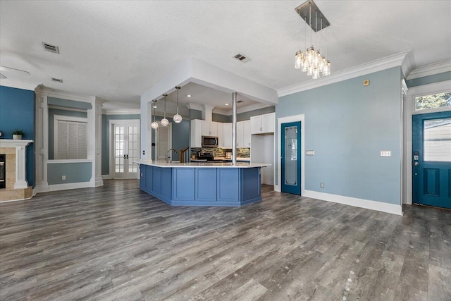 kitchen with pendant lighting, white cabinetry, hardwood / wood-style floors, and appliances with stainless steel finishes