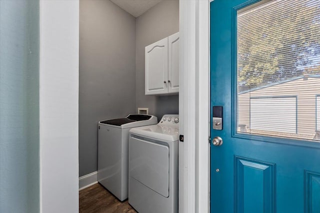 laundry area with cabinets, washing machine and dryer, and dark hardwood / wood-style floors