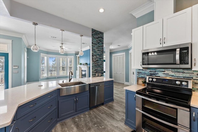 kitchen with blue cabinetry, pendant lighting, stainless steel appliances, and white cabinetry