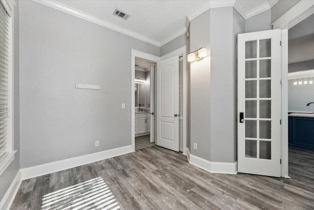 spare room featuring hardwood / wood-style floors, sink, crown molding, and a textured ceiling