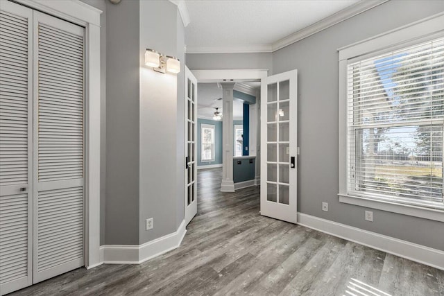 interior space with french doors, crown molding, a healthy amount of sunlight, and hardwood / wood-style floors