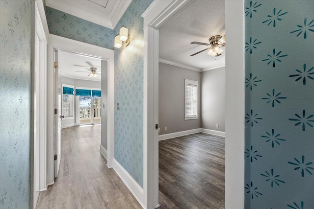 hallway with a textured ceiling, wood-type flooring, and crown molding