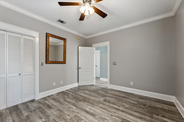 unfurnished bedroom with ceiling fan, ornamental molding, a textured ceiling, and hardwood / wood-style flooring