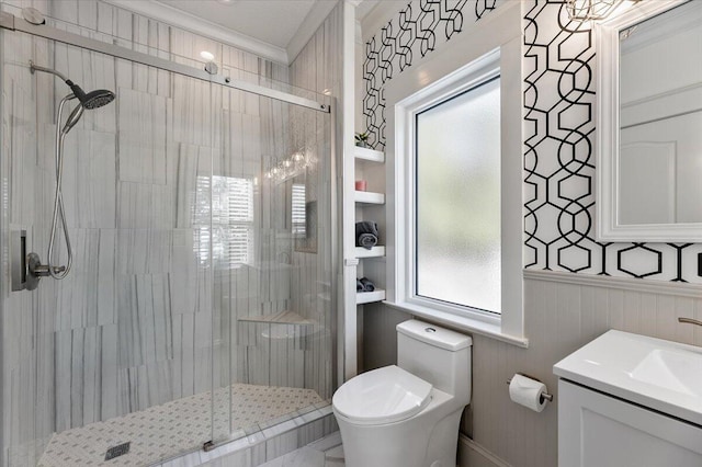 bathroom featuring vanity, toilet, walk in shower, and ornamental molding