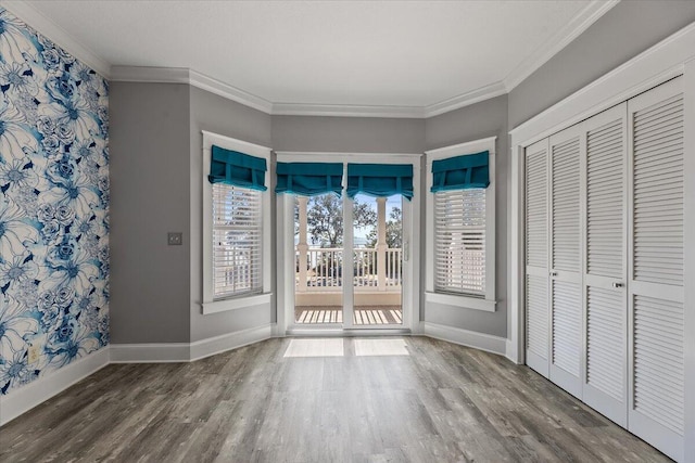 interior space with hardwood / wood-style flooring, access to exterior, ornamental molding, and a closet