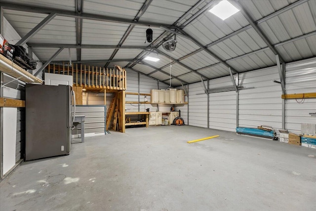 garage with stainless steel fridge and a garage door opener