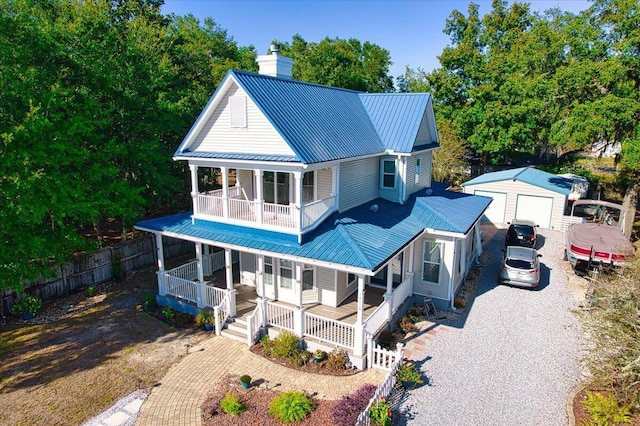 rear view of property with covered porch, an outbuilding, a garage, and a balcony