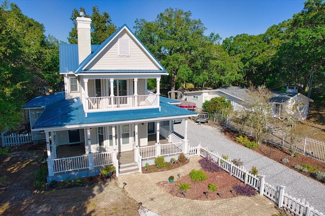 rear view of property featuring covered porch and a balcony