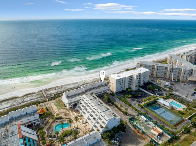 birds eye view of property with a water view and a beach view