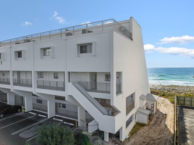 view of building exterior with a water view and a view of the beach