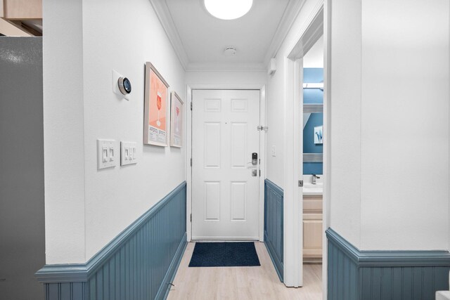 interior space featuring light wood-type flooring and crown molding