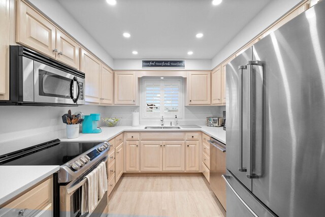 kitchen featuring light brown cabinetry, sink, and appliances with stainless steel finishes