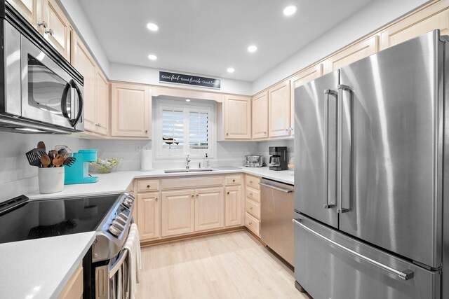 kitchen with light hardwood / wood-style floors, sink, stainless steel appliances, and light brown cabinetry