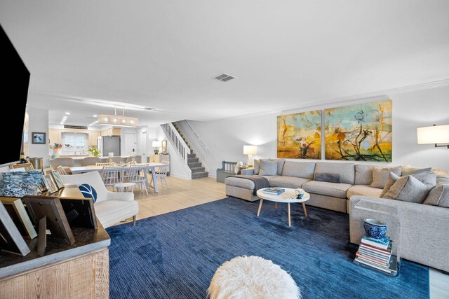 living room featuring hardwood / wood-style floors and crown molding