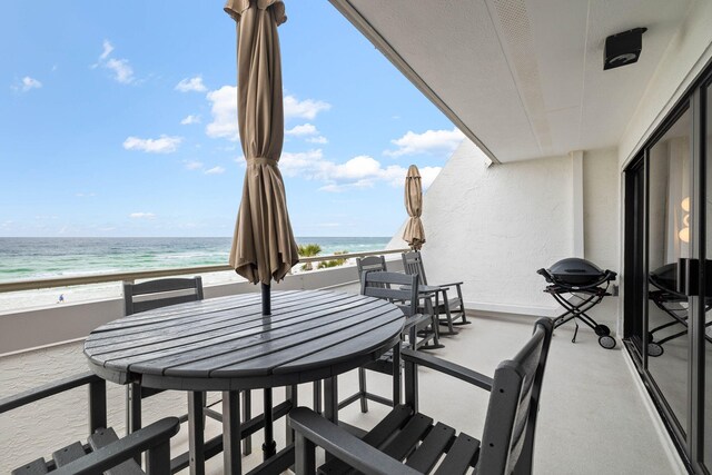 balcony featuring a water view and a beach view