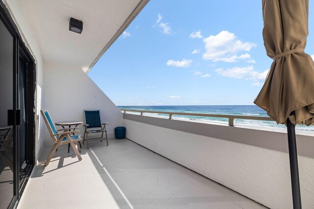 balcony featuring a water view and a view of the beach