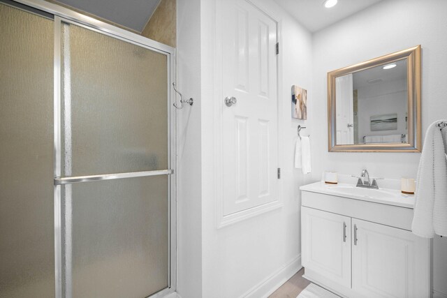 bathroom with vanity, wood-type flooring, and walk in shower