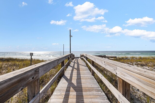 view of property's community with a water view and a view of the beach