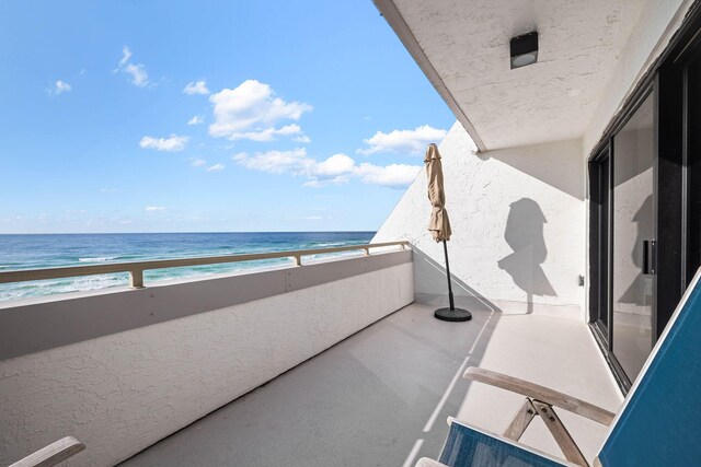 balcony with a water view and a beach view