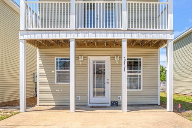 view of exterior entry featuring a balcony