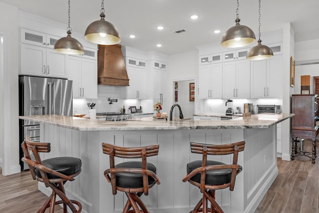 kitchen with premium range hood, decorative backsplash, and pendant lighting