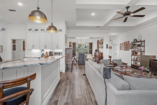 living room with crown molding, coffered ceiling, beam ceiling, and light hardwood / wood-style flooring