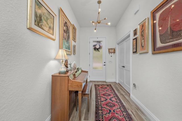 doorway to outside featuring wood-type flooring and a chandelier