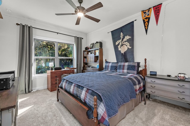 carpeted bedroom featuring crown molding and ceiling fan