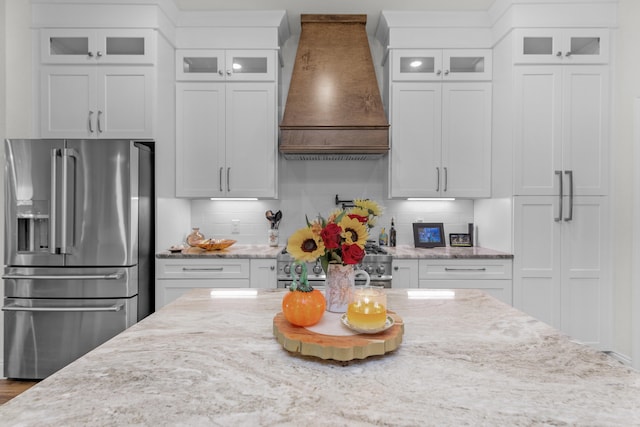 kitchen with backsplash, appliances with stainless steel finishes, custom range hood, and white cabinets