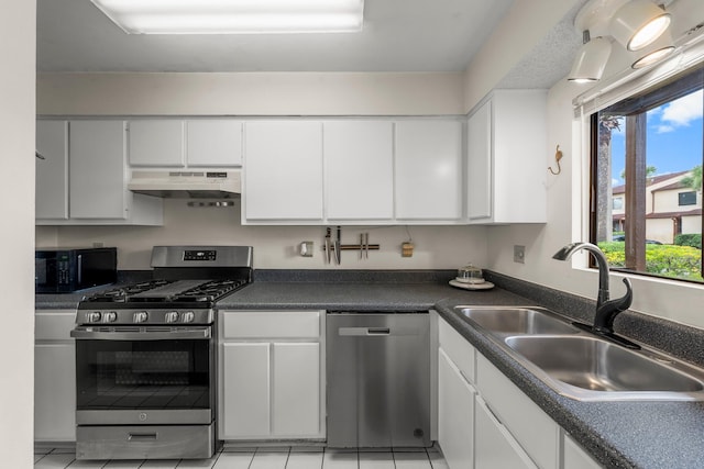 17751 Panama City Beach Pkwy Unit 13E, Panama City Beach, FL 32413 - kitchen with stainless steel appliances, under cabinet range hood, a sink, white cabinets, and dark countertops