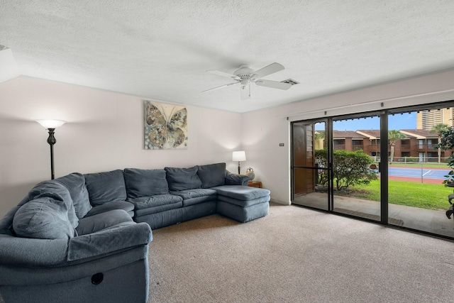 carpeted living room featuring a textured ceiling, ceiling fan, and lofted ceiling