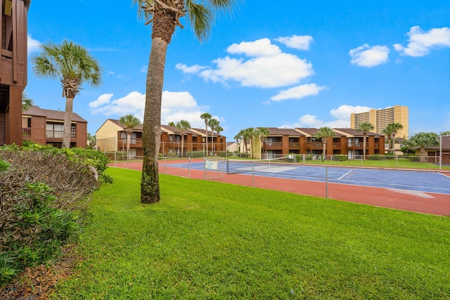 view of sport court with basketball hoop and a yard