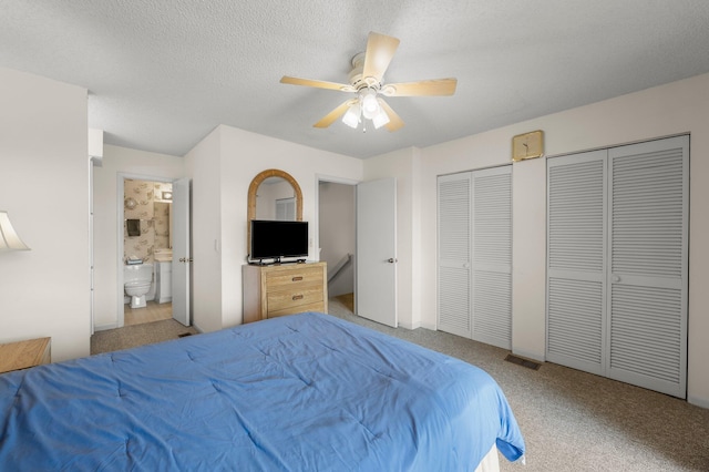 17751 Panama City Beach Pkwy Unit 13E, Panama City Beach, FL 32413 - carpeted bedroom featuring two closets, a ceiling fan, ensuite bathroom, and a textured ceiling