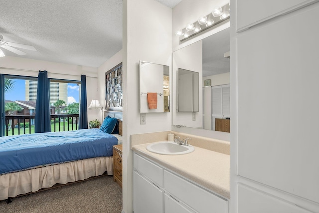 carpeted bedroom with a textured ceiling, ceiling fan, access to exterior, and sink